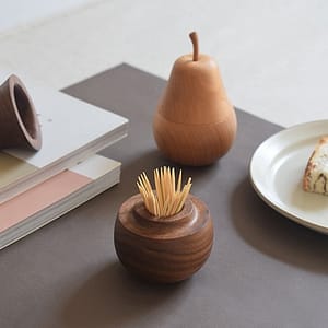 beech and dark walnut wooded toothpick holder in pear shape lifestyle shot with cake