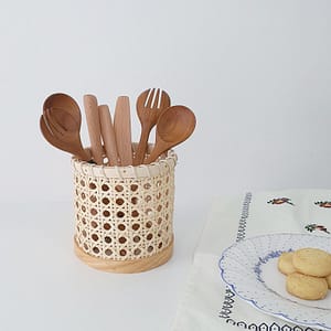 rattan kitchen organizer for cutlery utensils lifestyle shot with wooden cutlery and a plate of biscuit