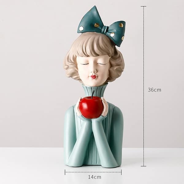 Girl in green sweater with red apple home decor display statue